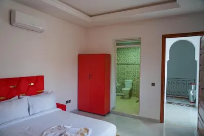 a bedroom with a red cabinet and a door to a yard at Marrakesh Villa 1 in Marrakech