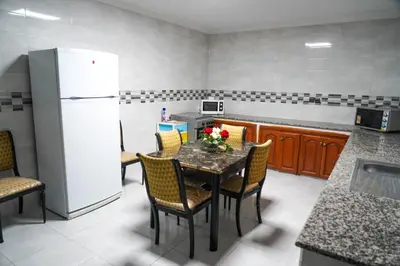 a kitchen with a table with chairs and a refrigerator at Marrakesh Villa 1 in Marrakech