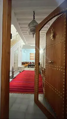 a view of a hallway with a red carpet and a door at Riad EL BADIS in Marrakech