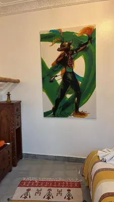 a painting of a woman hanging on a wall at Riad EL BADIS in Marrakech
