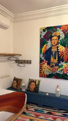 a bedroom with a large painting on the wall at Riad EL BADIS in Marrakech