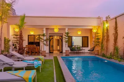 a villa with a swimming pool and patio furniture at Villa loujain in Marrakech