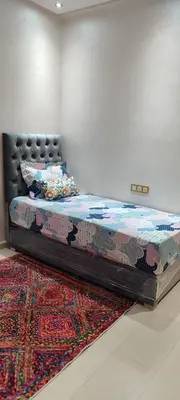 a bed in a room with a rug at Dar lala soukaina in Marrakech