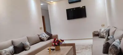 a living room with a couch and a tv on a wall at Dar lala soukaina in Marrakech