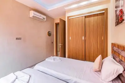 a bedroom with a bed and a wooden door at Marguerite de Guéliz Piscine & Parking in Marrakech