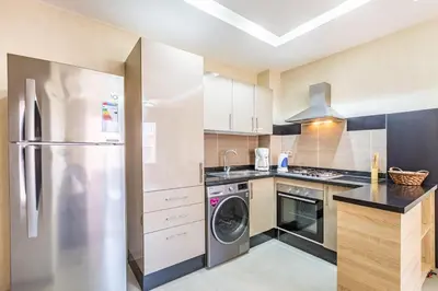 a kitchen with a stainless steel refrigerator and a dishwasher at Marguerite de Guéliz Piscine & Parking in Marrakech