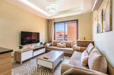 a living room with a couch and a tv at Marguerite de Guéliz Piscine & Parking in Marrakech