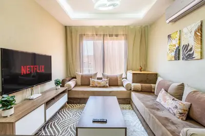 a living room with a couch and a tv at Marguerite de Guéliz Piscine & Parking in Marrakech