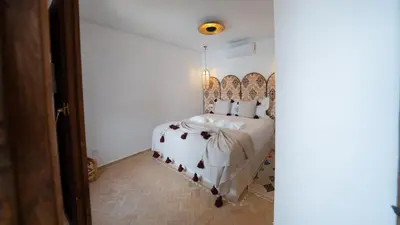 a bedroom with a bed with a headboard at Riad 2 Ksour Marrakesh in Marrakech