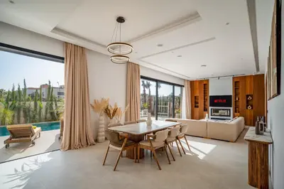 a living room with a table and chairs and a couch at Villa Bahia Luxury-Pool Breakfast & Golf Access in Marrakech