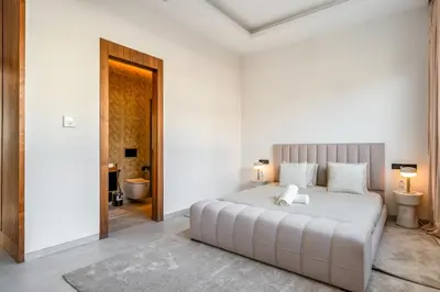 a bedroom with a large white bed and a bathroom at Villa Bahia Luxury-Pool Breakfast & Golf Access in Marrakech