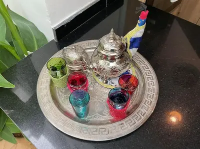 a silver tray with four different colored glasses on a table at Riad zouine dans un quartier traditionnel in Marrakech