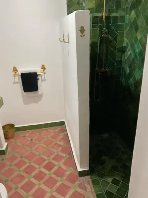a bathroom with a shower and a tiled floor at Riad zouine dans un quartier traditionnel in Marrakech