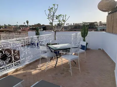 a patio with a table and chairs on a balcony at Riad zouine dans un quartier traditionnel in Marrakech