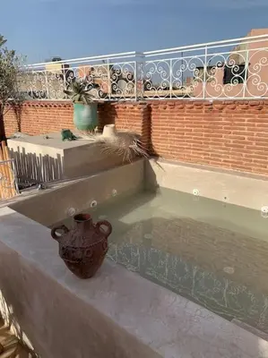 a vase sitting on the ledge of a balcony at Riad zouine dans un quartier traditionnel in Marrakech