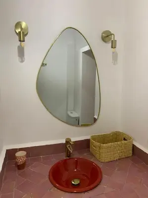 a bathroom with a mirror and a red sink at Riad zouine dans un quartier traditionnel in Marrakech