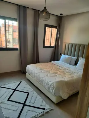a bed in a bedroom with two windows at Appartement à Guéliz avec belle terrasse in Marrakech