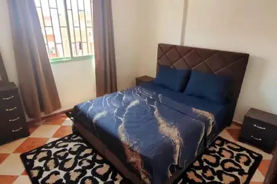 a bedroom with a bed with a blue comforter at Appartement familial in Marrakech