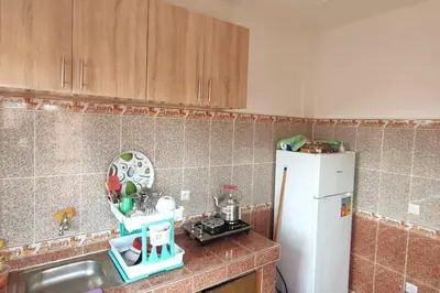 a kitchen with a sink and a white refrigerator at Appartement familial in Marrakech