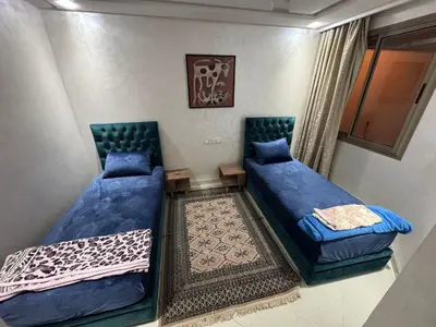 two beds with blue pillows in a room at Apartment in Marrakech in Marrakech