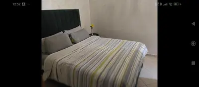 a bedroom with a bed with a striped blanket at Appartement DUPLEX in Marrakech