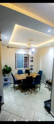 a dining room with a table and blue chairs at Appartement DUPLEX in Marrakech