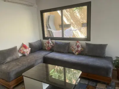 a living room with a couch and a window at Studio avec SDB salon tele kitchenette privé dans une villa piscine, calme et commodités in Marrakech