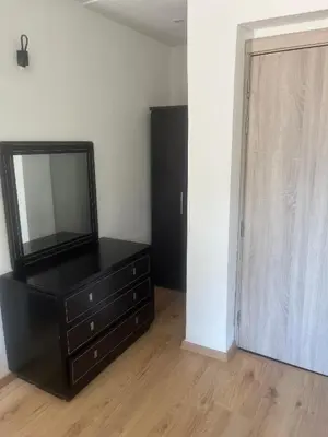 a black dresser with a television on top of it at Studio avec SDB salon tele kitchenette privé dans une villa piscine, calme et commodités in Marrakech
