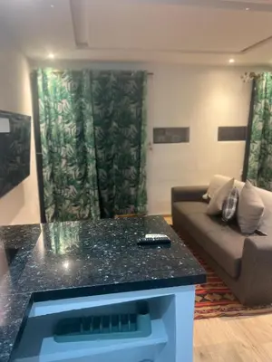 a living room with a table and a couch at Studio avec SDB salon tele kitchenette privé dans une villa piscine, calme et commodités in Marrakech