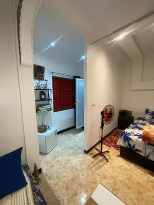 a bedroom with a room with a bed and a fan at Suite 2 in Marrakech