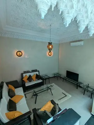 a living room with a couch and a chandelier at Riad du village in Marrakech