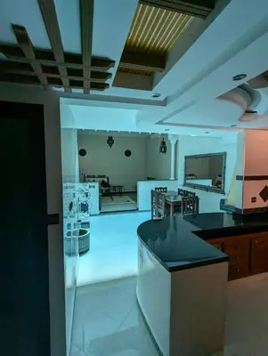 a kitchen and living room with a counter and a table at Riad du village in Marrakech