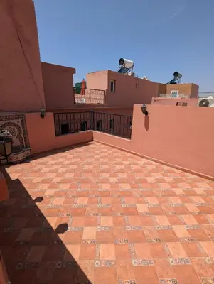 a balcony of a house with a brick patio at Riad du village in Marrakech