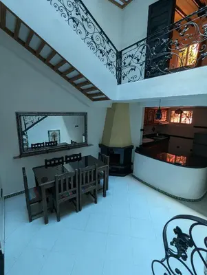 a living room with a table and chairs and a fireplace at Riad du village in Marrakech