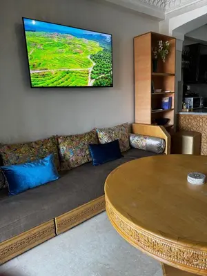 a living room with a couch and a tv on the wall at Luxury Gueliz Apartment-Miramas 2 in Marrakech