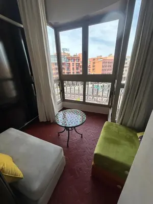 a room with a bed and a table and a window at Luxury Gueliz Apartment-Miramas 2 in Marrakech