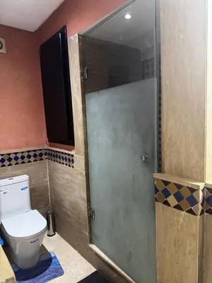 a bathroom with a toilet and a glass shower door at Luxury Gueliz Apartment-Miramas 2 in Marrakech