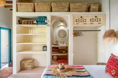 a room with a shelf with baskets and a bed at Riad Dar Palma Heated Pool Jacuzzi Heart Of Marrakech Medina in Marrakech