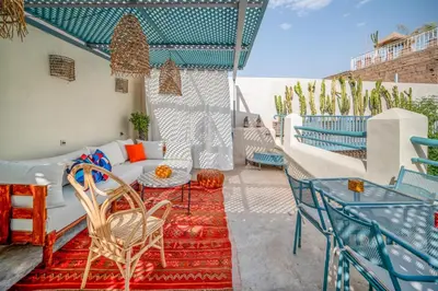 a patio with a couch and chairs on a balcony at Riad Dar Palma Heated Pool Jacuzzi Heart Of Marrakech Medina in Marrakech