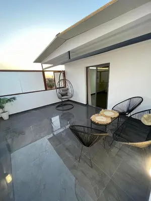a living room with two chairs and a table at Chic Duplex Central 3 Suites et Wi-Fi in Marrakech