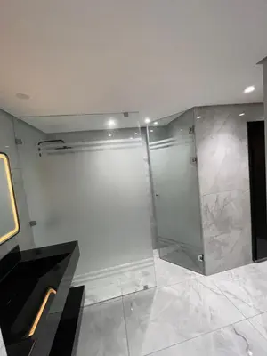 a bathroom with a shower with a glass wall at Chic Duplex Central 3 Suites et Wi-Fi in Marrakech