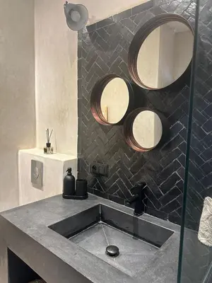 a bathroom with a sink and two mirrors at Riad Daba Chic in Marrakech