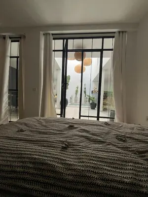 a bedroom with a bed and a large window at Riad Daba Chic in Marrakech