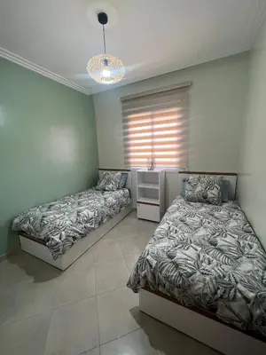 a bedroom with two beds and a window at Brand new cozy apartment in Marrakech
