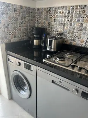 a kitchen with a stove and a washing machine at Brand new cozy apartment in Marrakech