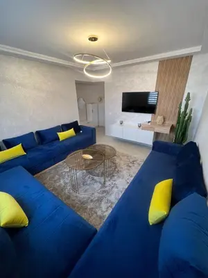 a living room with a blue couch and yellow pillows at Brand new cozy apartment in Marrakech