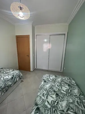 a bedroom with two beds and a chandelier at Brand new cozy apartment in Marrakech