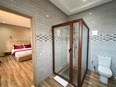 a bathroom with a shower and a toilet and a bed at Villa privée in Marrakech