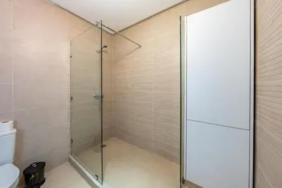 a shower with glass doors in a bathroom at Appartement au coeur de Marrakech à côté de la gare avec piscine in Marrakech