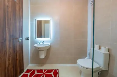 a bathroom with a toilet and a sink and a mirror at Appartement au coeur de Marrakech à côté de la gare avec piscine in Marrakech